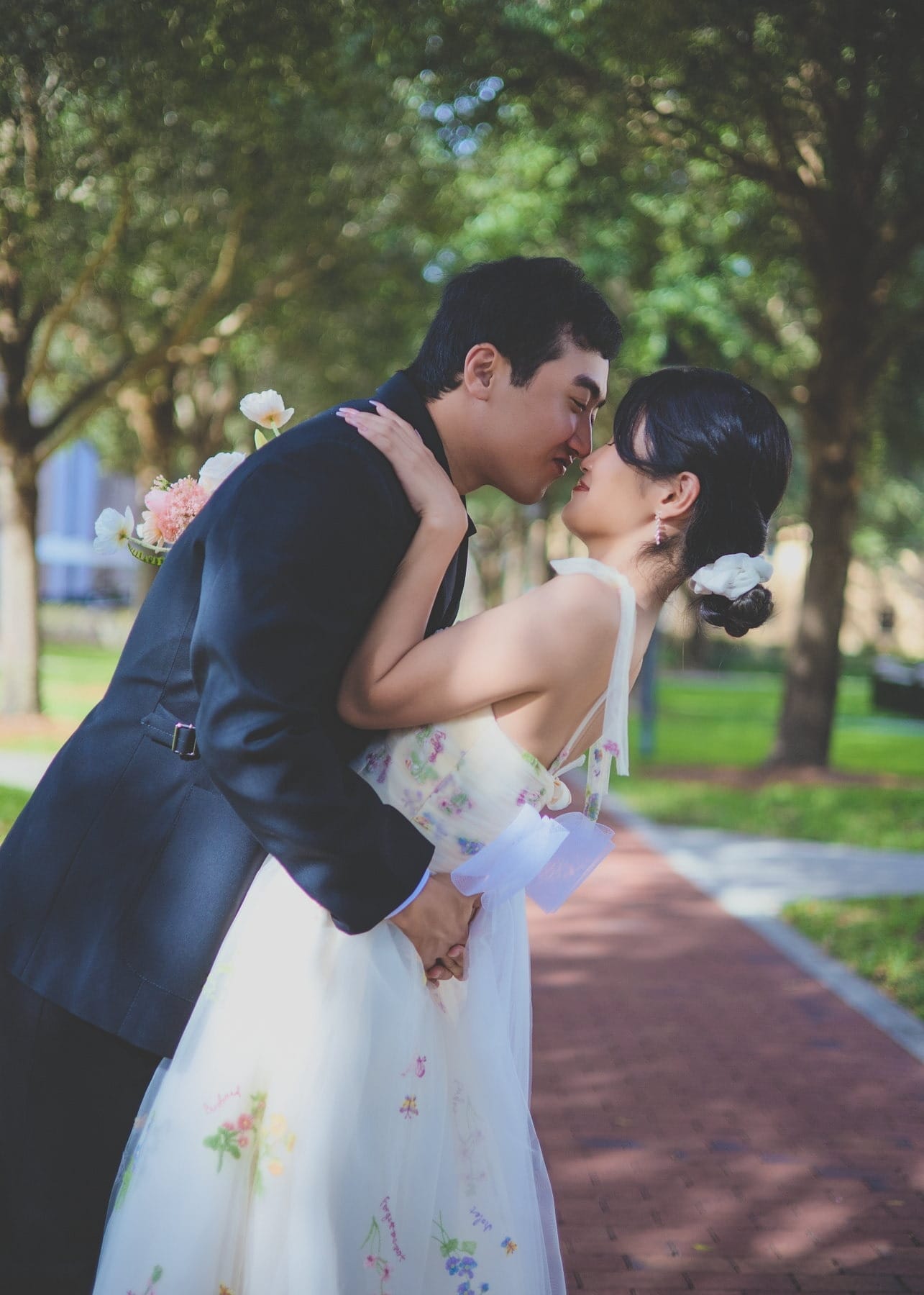 Couple leaning toward one another beneath trees