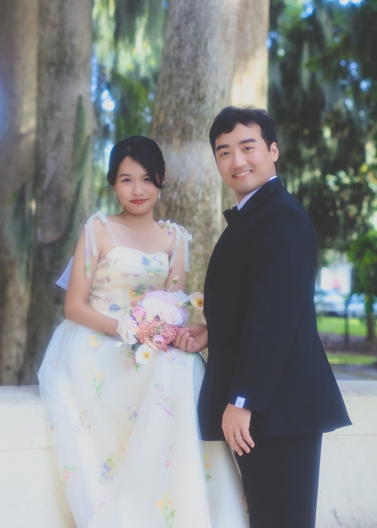 Bride with a bouquet beside the groom among palms