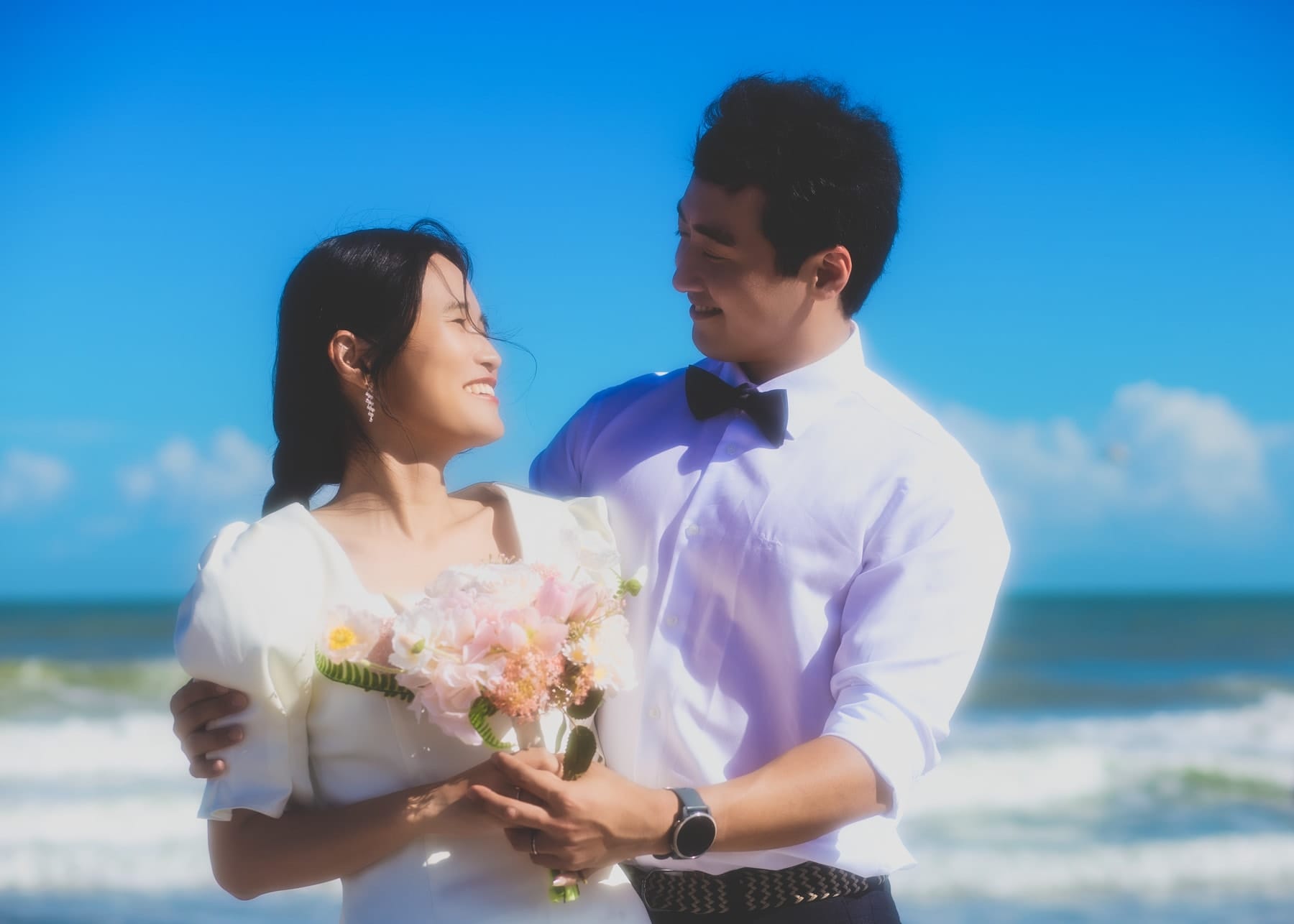 Couple laughing face to face on the beach