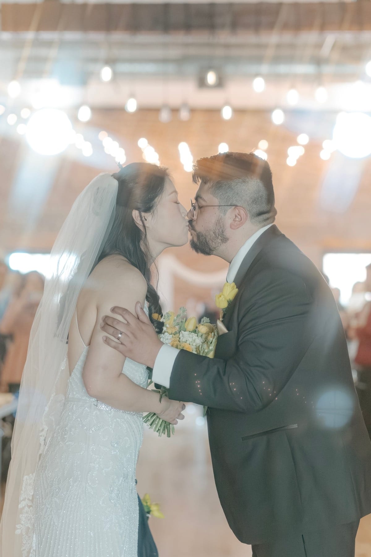 The couple's kiss beneath string lights