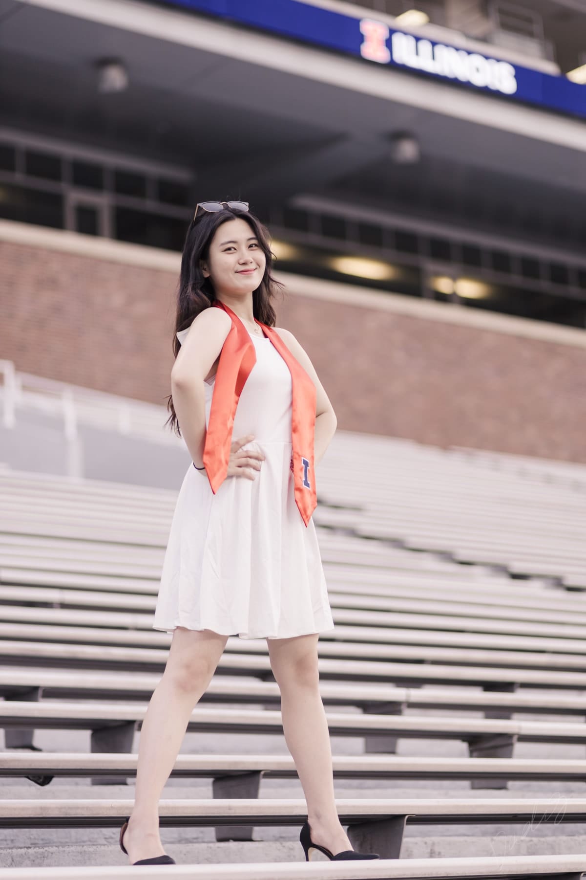 Graduate posing on the stadium steps