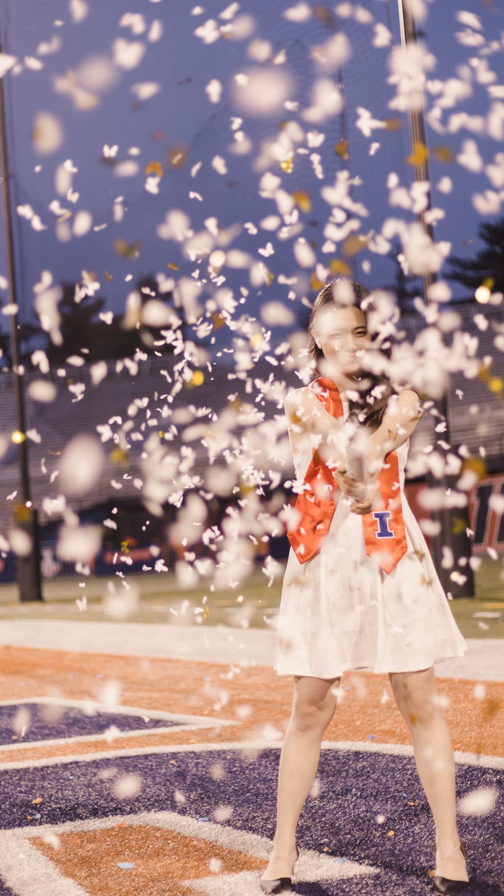 Graduate laughing beneath falling confetti