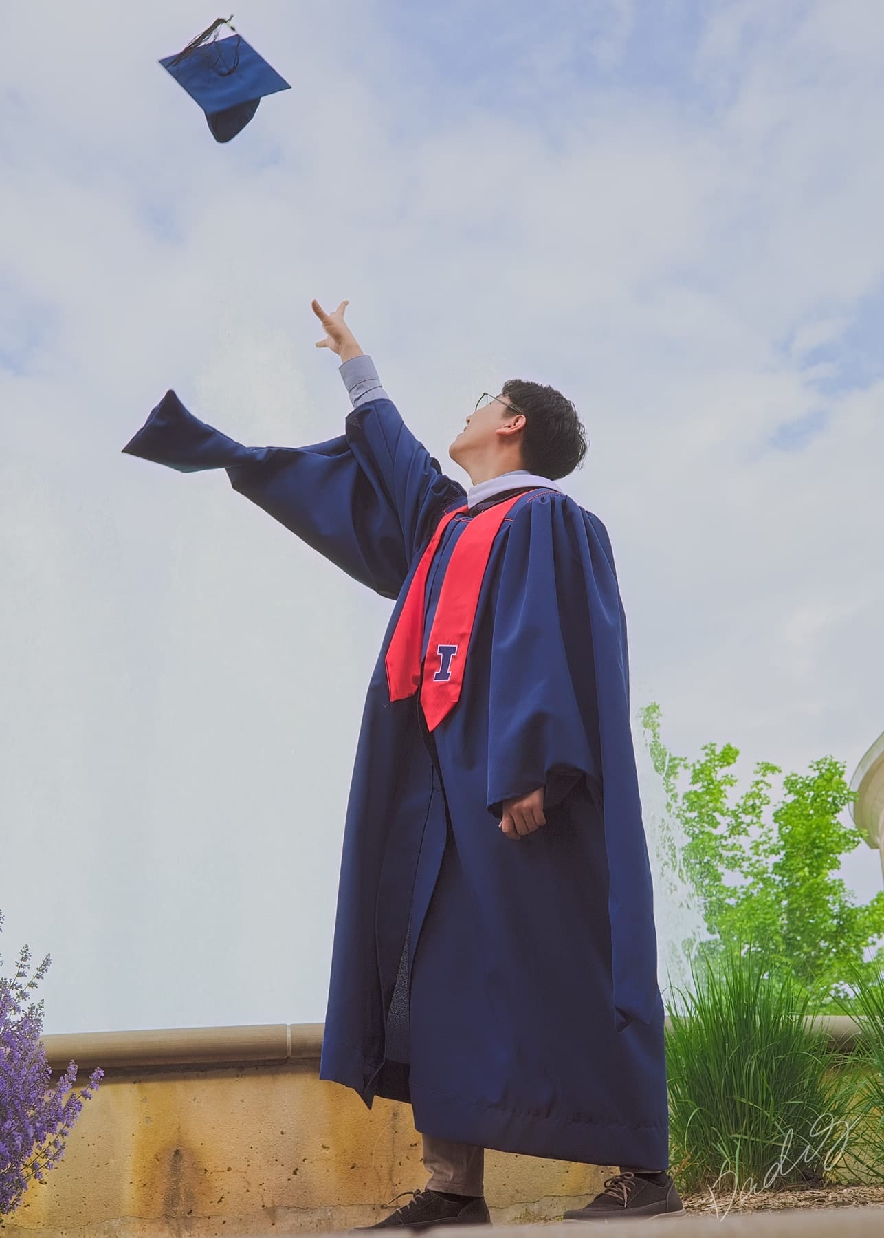 Graduate tossing his cap against a blue sky