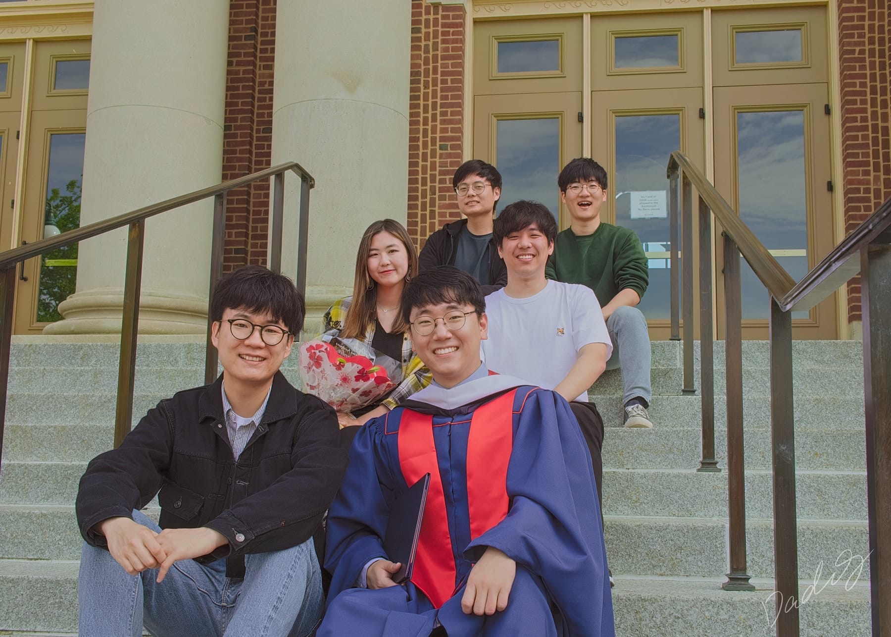Graduate and friends gathered on building steps