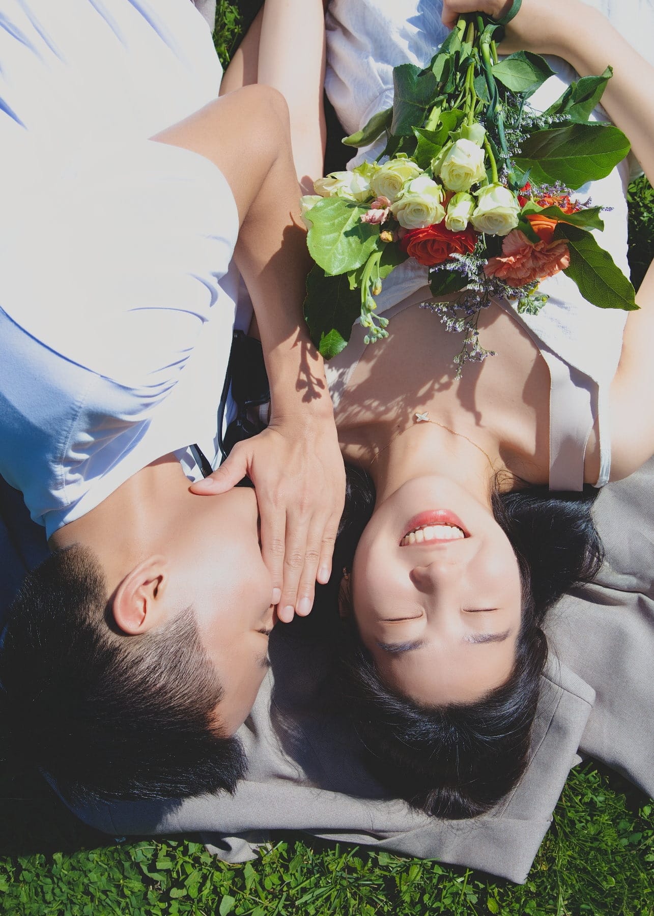Close overhead portrait of a couple lying on the grass