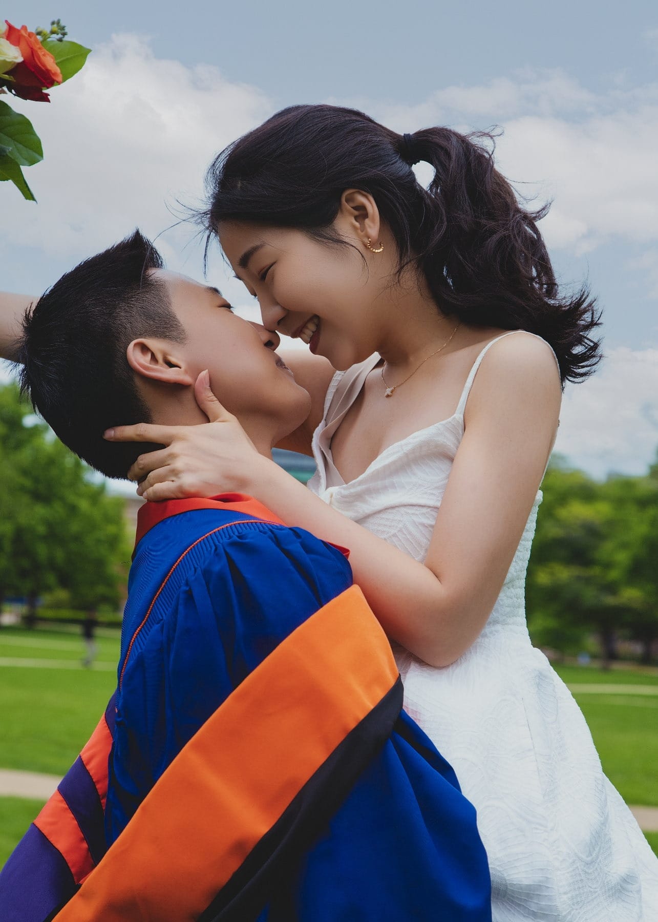 Graduation couple sharing a quiet portrait in academic regalia