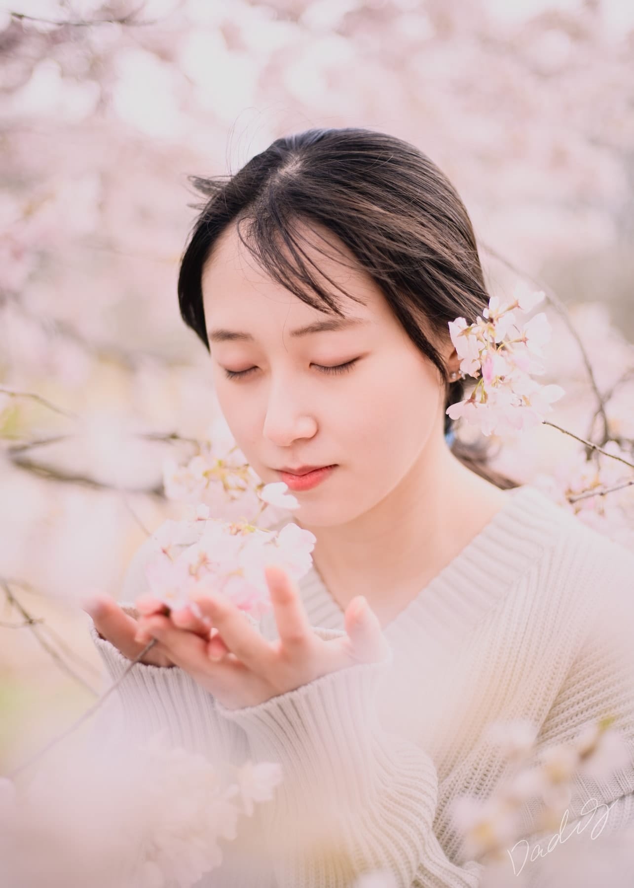 Portrait with eyes closed among cherry blossoms