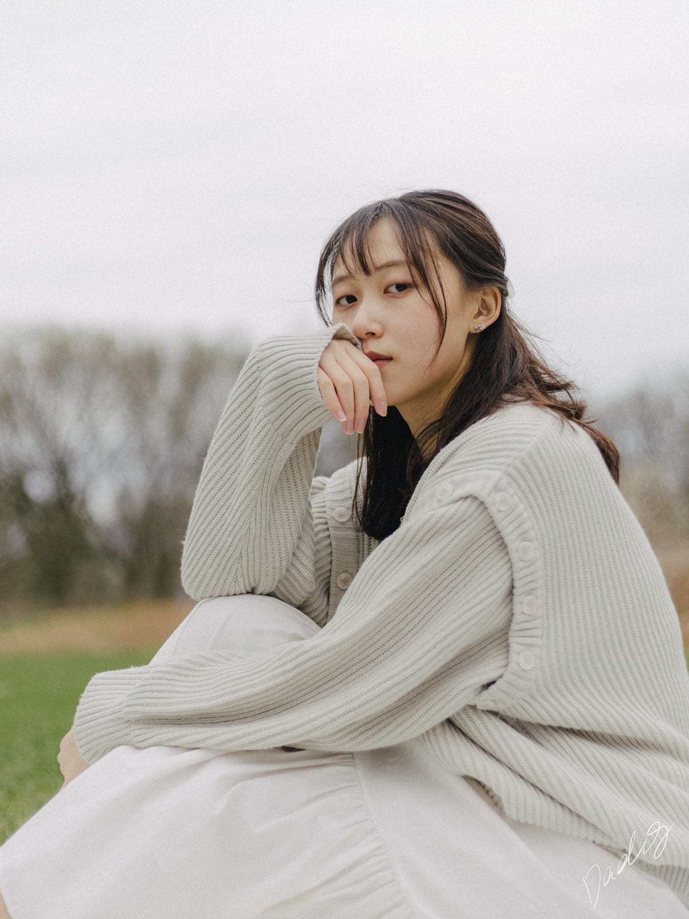 Seated portrait in a cream knit sweater