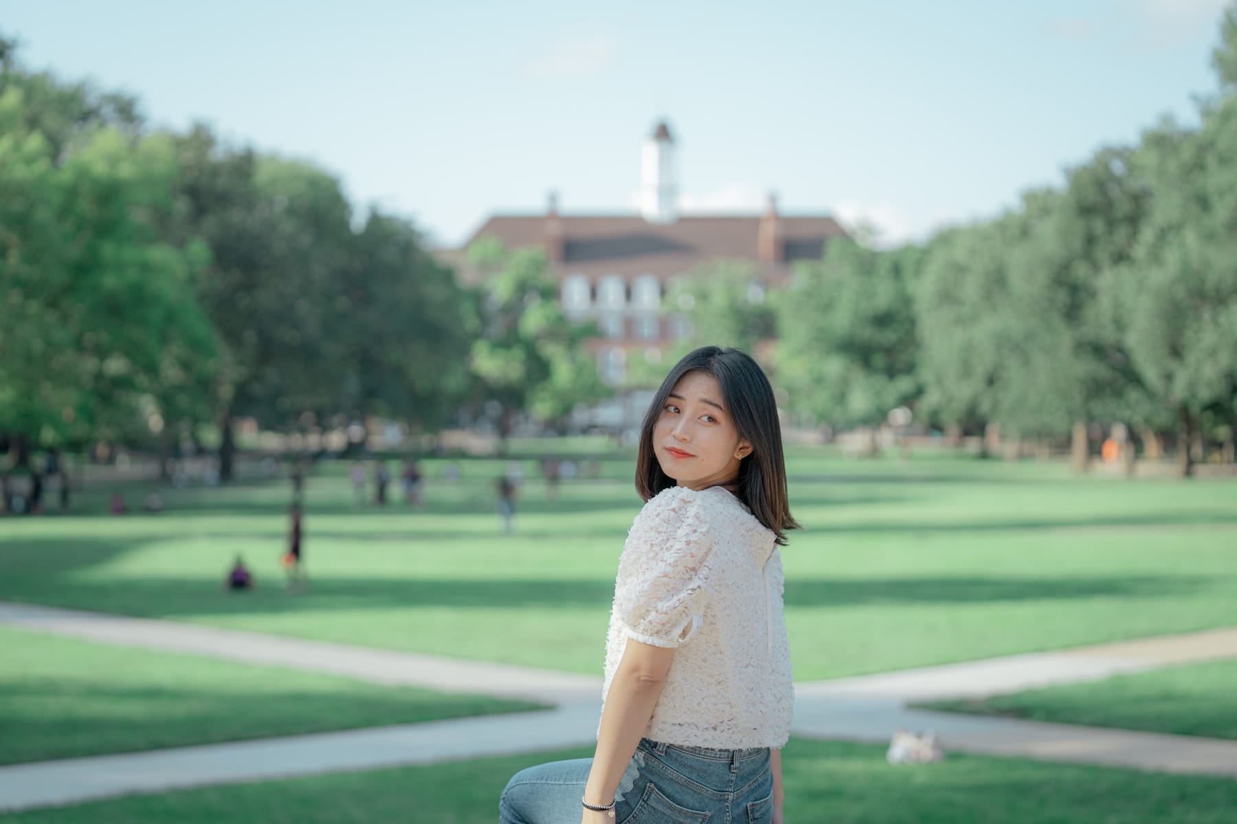 Looking back over her shoulder on a sunny campus lawn