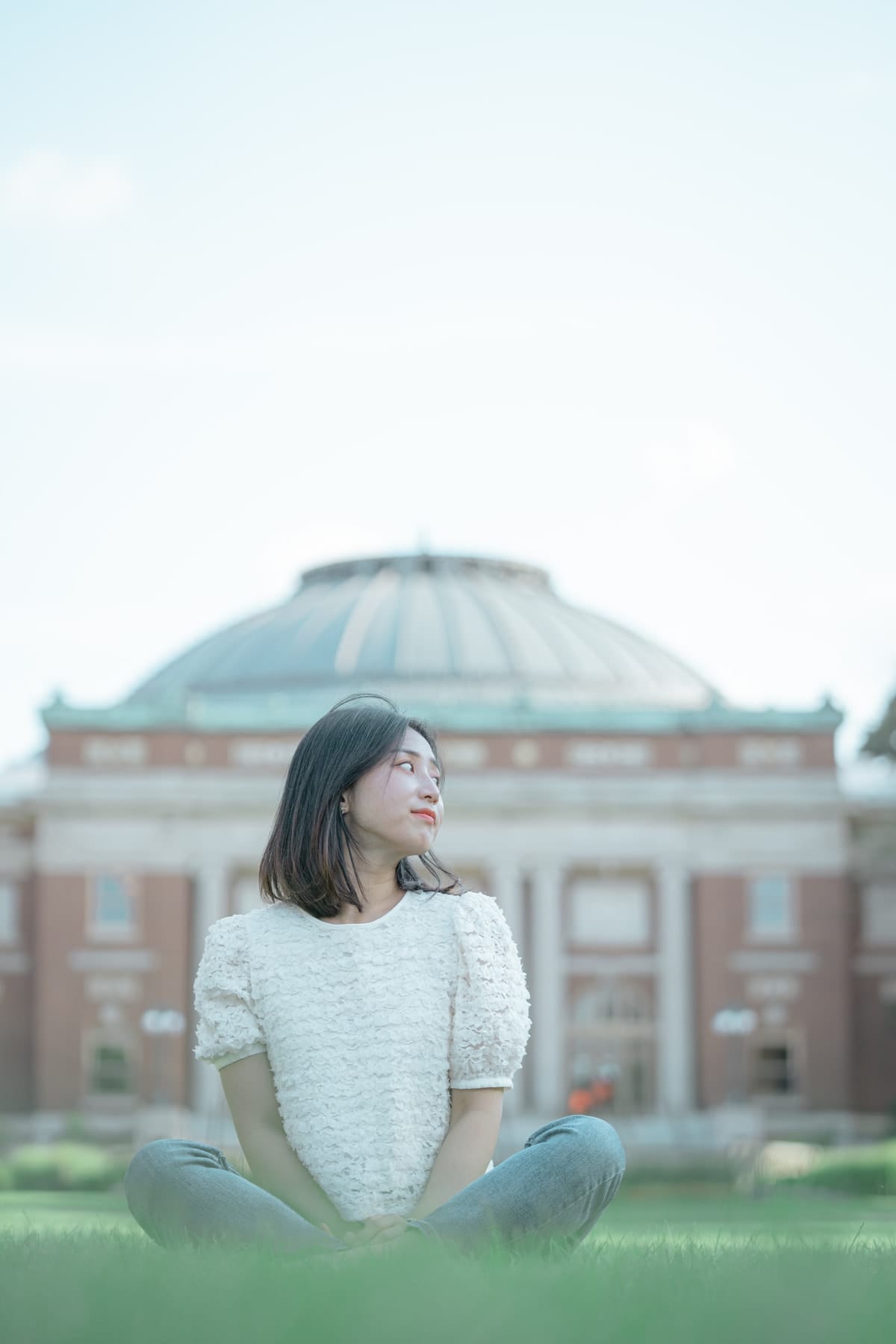 Seated on the grass before the domed auditorium