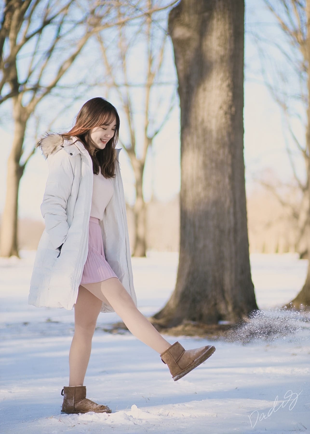 Walking through fresh snow beneath bare trees