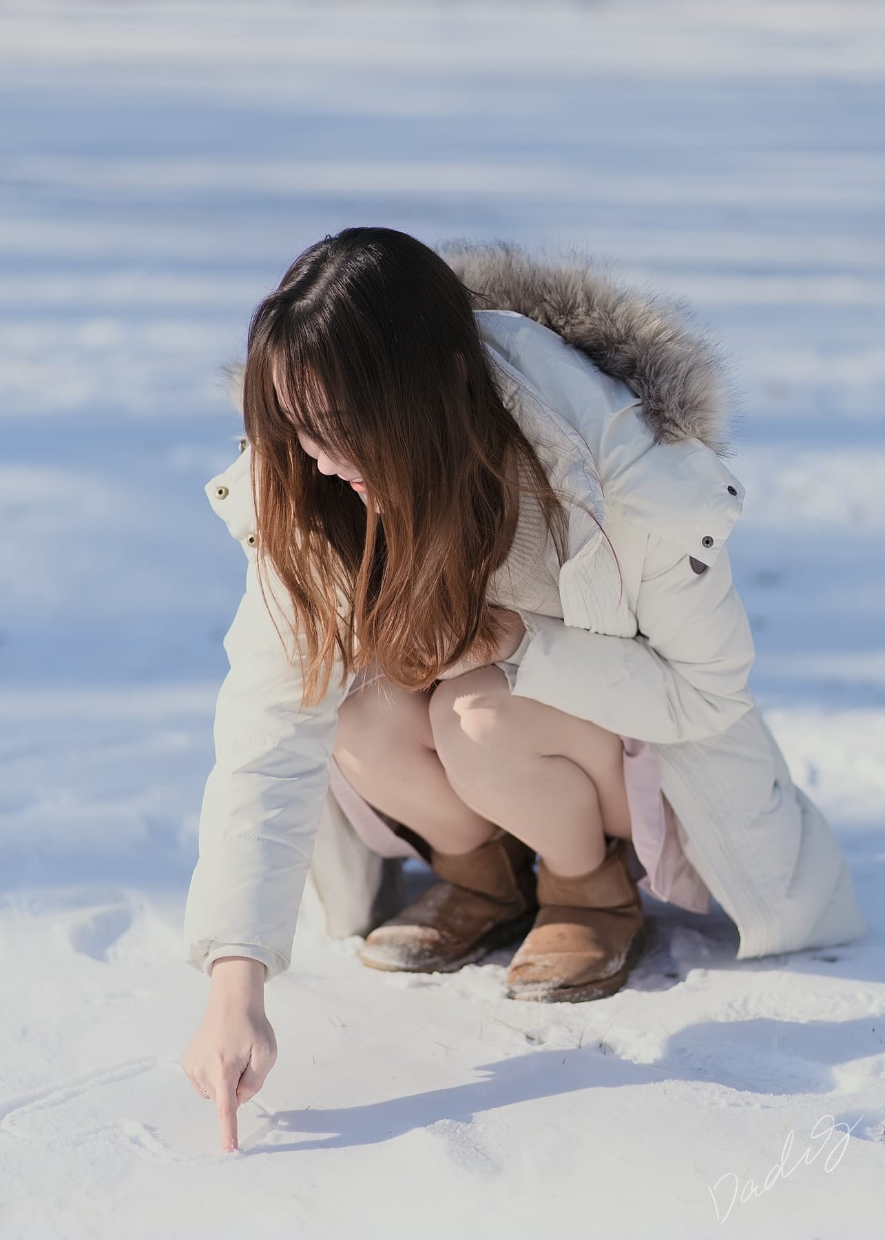 Crouching to draw in the snow