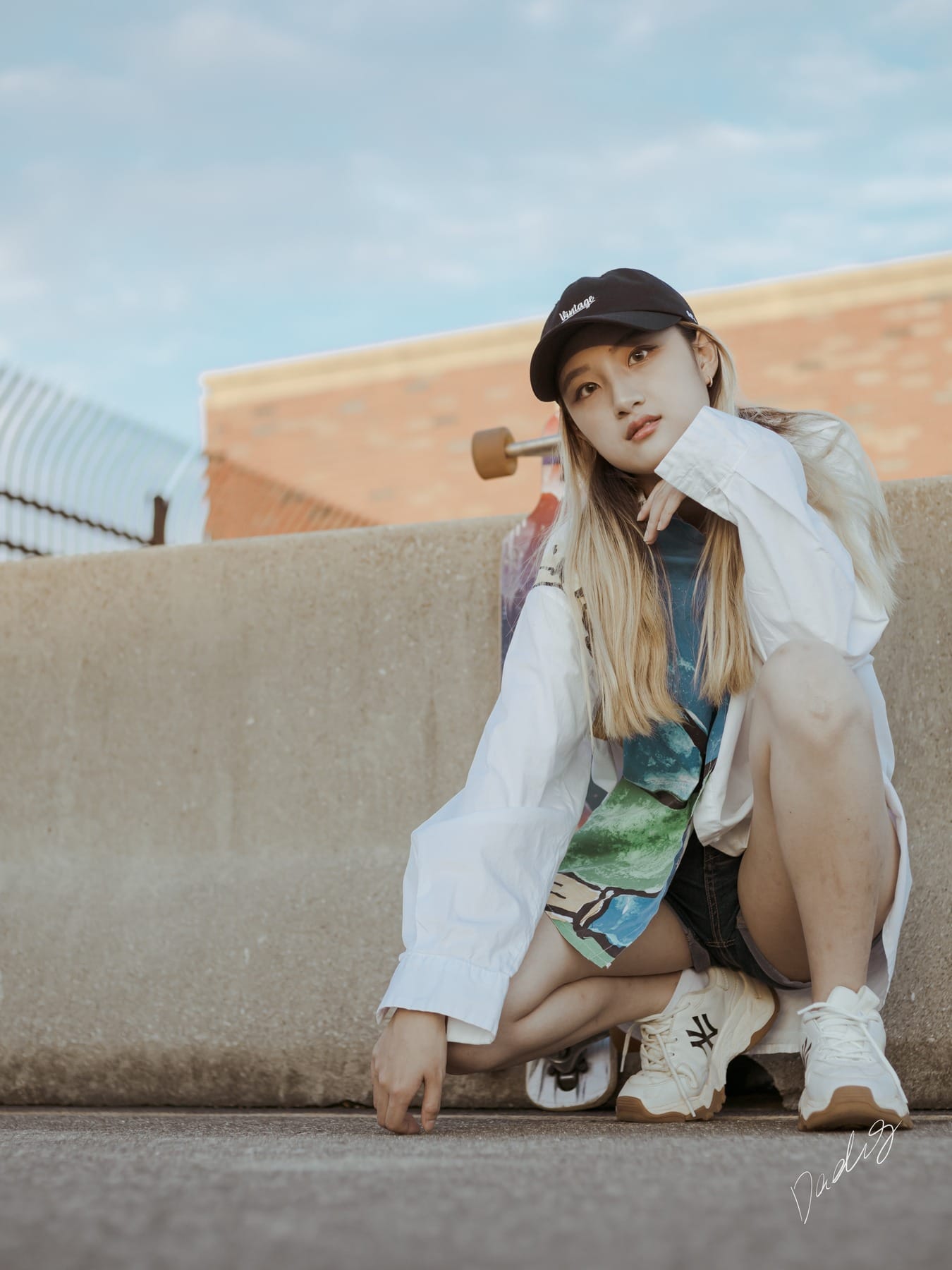 Crouched portrait beside a concrete barrier