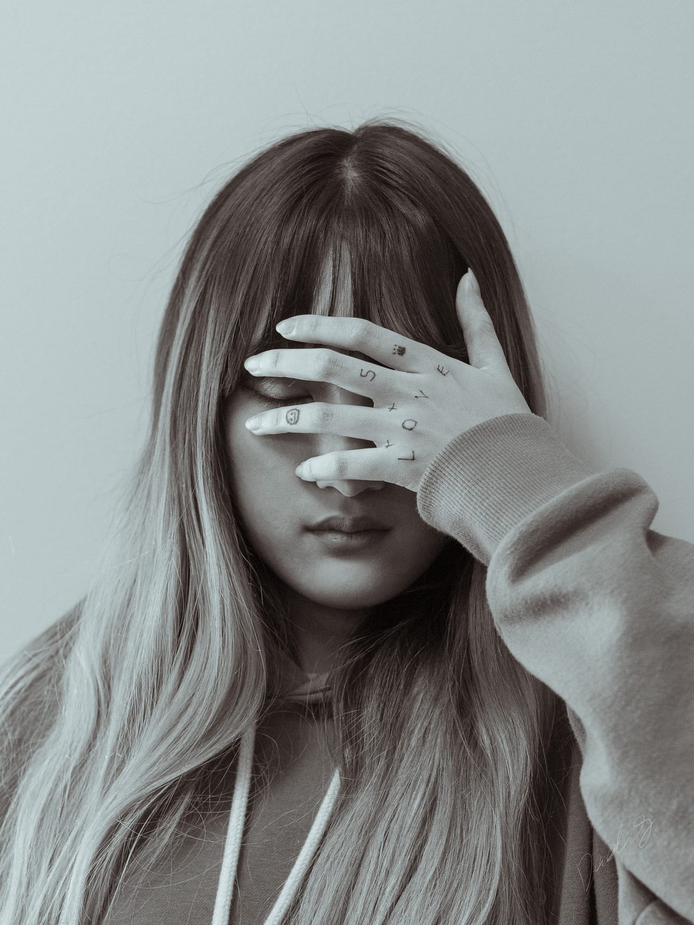Muted close-up with a hand across the face